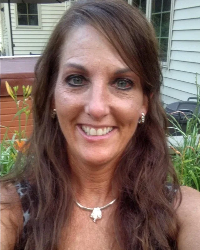 Therese, a 61-year-old BetterBrain client, smiling outdoors
